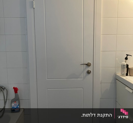 דלת פנים לבנה מעוצבת מותקנת בכניסה לחדר רחצה